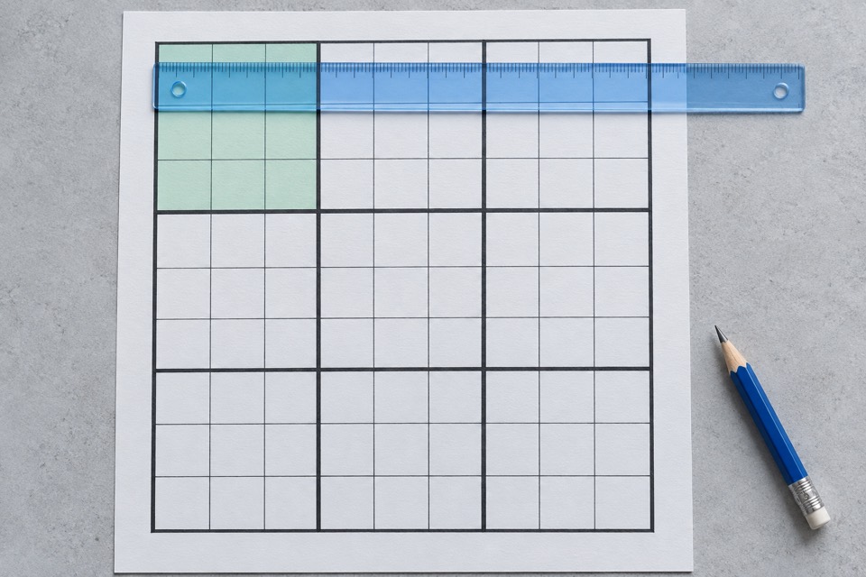 Illustration of a mint-highlighted Sudoku box and a blue ruler extending across its row on white paper.